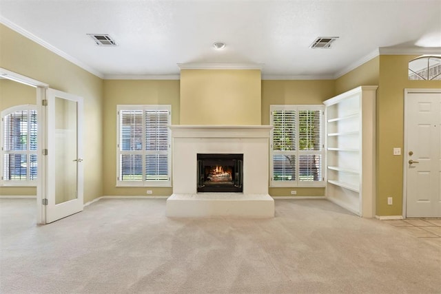 unfurnished living room featuring carpet, a lit fireplace, baseboards, healthy amount of natural light, and crown molding