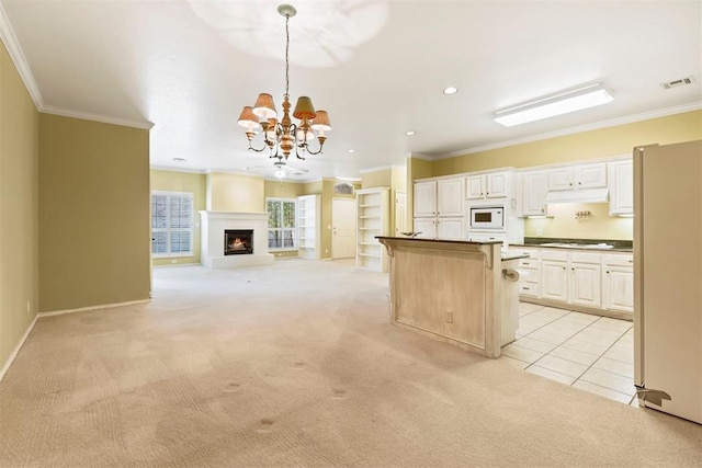 kitchen featuring white appliances, light colored carpet, ornamental molding, a chandelier, and open floor plan