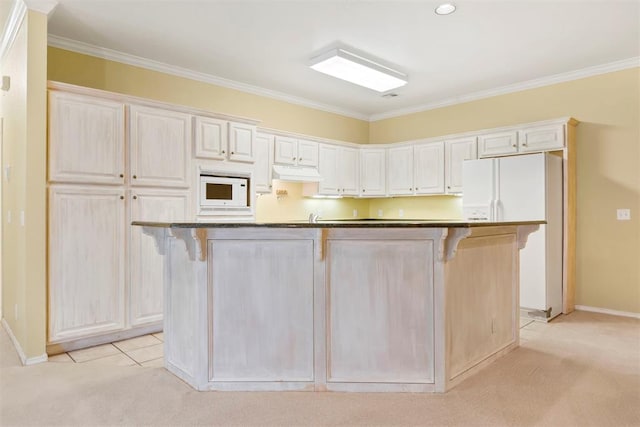 kitchen with light colored carpet, under cabinet range hood, a breakfast bar area, crown molding, and white appliances