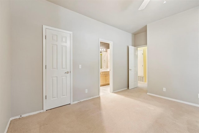 unfurnished bedroom with light carpet, baseboards, connected bathroom, and ceiling fan