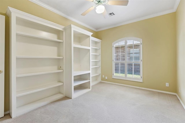 carpeted spare room with crown molding, a ceiling fan, and baseboards