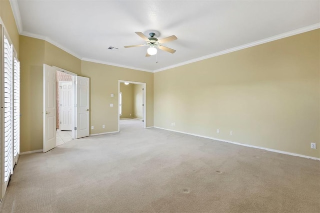 spare room featuring ceiling fan, ornamental molding, light colored carpet, and baseboards