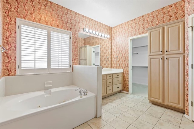 full bathroom featuring wallpapered walls, a whirlpool tub, vanity, tile patterned floors, and a spacious closet
