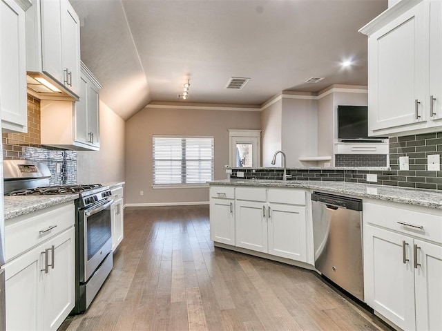 2408 Santa Monica St, Edmond, OK 73034 - kitchen featuring appliances with stainless steel finishes, a peninsula, baseboards, a sink, and backsplash