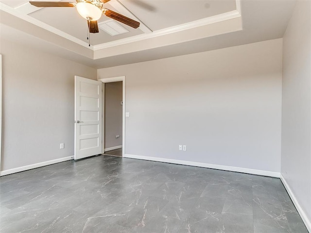 2408 Santa Monica St, Edmond, OK 73034 - empty room featuring baseboards, ceiling fan, a tray ceiling, ornamental molding, and marble look tiles