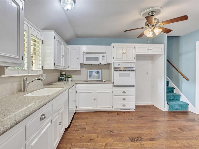 6120 Kingston Rd, Oklahoma City, OK 73122 - kitchen featuring white appliances, a sink, ceiling fan, white cabinetry, and wood finished floors