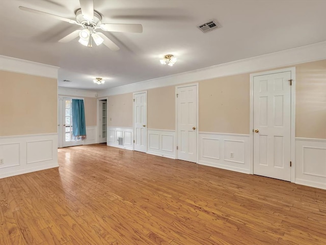 6120 Kingston Rd, Oklahoma City, OK 73122 - empty room with ornamental molding, wainscoting, light wood-style floors, ceiling fan, and a decorative wall