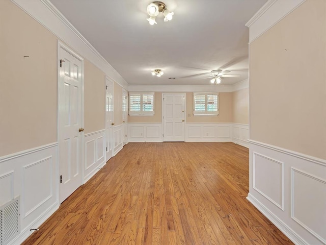 6120 Kingston Rd, Oklahoma City, OK 73122 - unfurnished room with a decorative wall, a wainscoted wall, ceiling fan, light wood-style floors, and crown molding