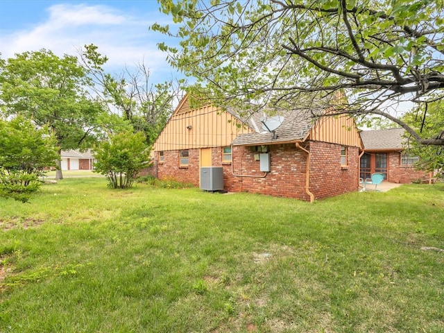 6120 Kingston Rd, Oklahoma City, OK 73122 - view of property exterior featuring central air condition unit, brick siding, a yard, and board and batten siding