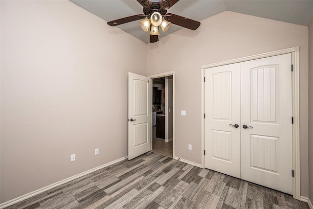 805 Evening Dr, Yukon, OK 73099 - unfurnished bedroom with wood finished floors, vaulted ceiling, a closet, baseboards, and a ceiling fan