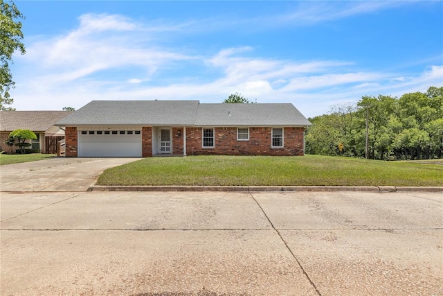 single story home with driveway, an attached garage, a front yard, and brick siding