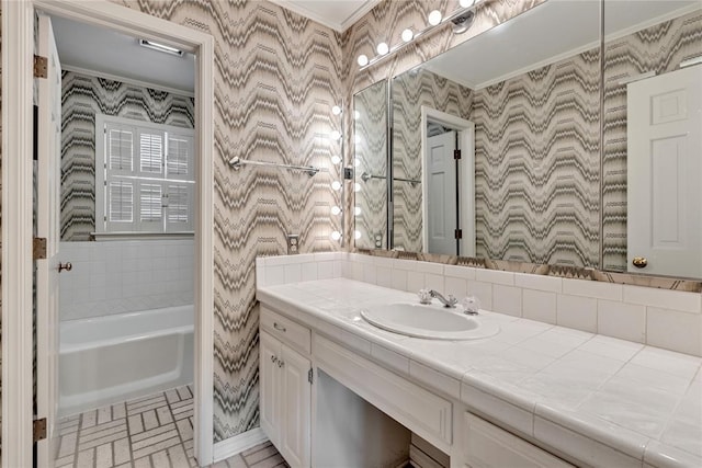 bathroom featuring ornamental molding, wallpapered walls, vanity, brick patterned floors, and a bath
