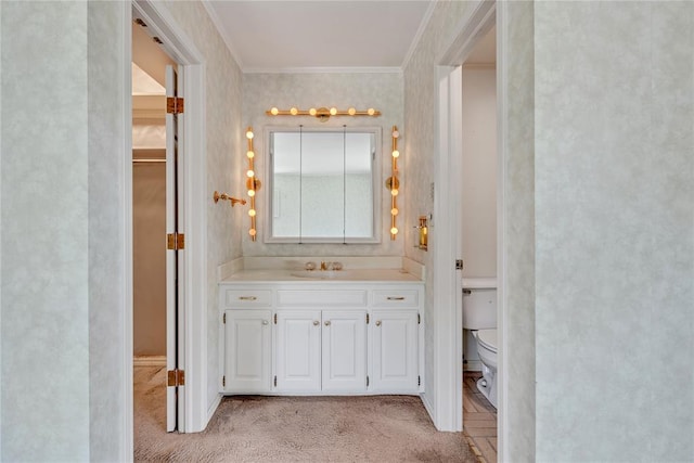 bathroom with toilet, ornamental molding, and vanity