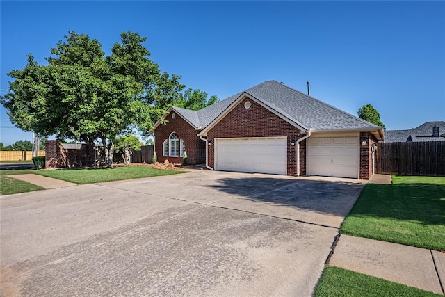 3001 NE 129th St, Edmond, OK 73013 - view of front of house featuring brick siding, a garage, driveway, and roof with shingles