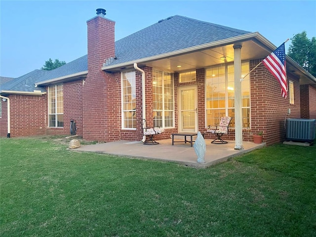 3001 NE 129th St, Edmond, OK 73013 - rear view of property with a shingled roof, brick siding, central air condition unit, a lawn, and a patio area