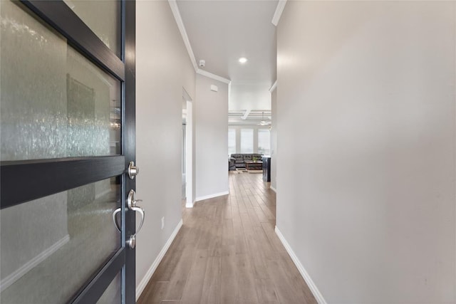 hallway with ornamental molding, baseboards, wood finished floors, and recessed lighting