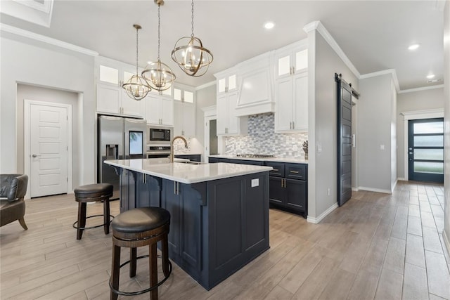 kitchen featuring stainless steel appliances, a chandelier, light countertops, a breakfast bar, and a sink