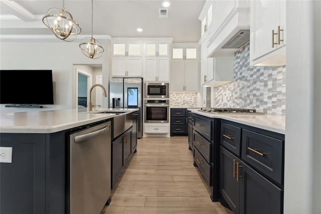 kitchen featuring appliances with stainless steel finishes, recessed lighting, light wood-style flooring, a chandelier, and white cabinetry