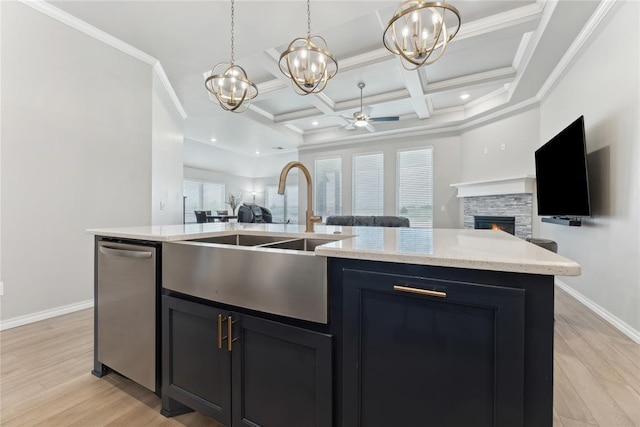 kitchen with a sink, open floor plan, a stone fireplace, a chandelier, and coffered ceiling