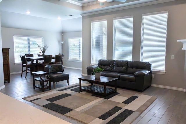 living room with ornamental molding, baseboards, light wood-type flooring, and ceiling fan