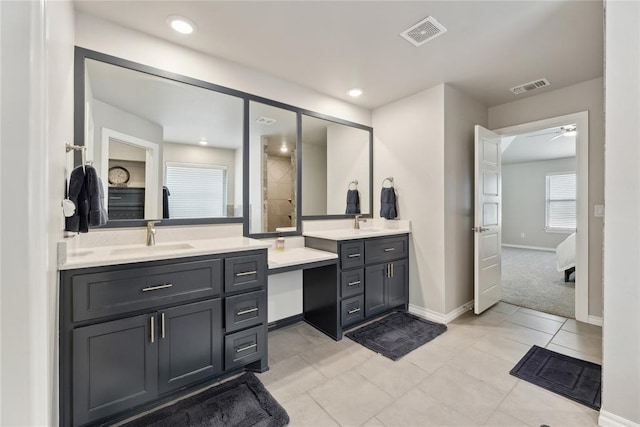 bathroom with two vanities, baseboards, a ceiling fan, and tile patterned flooring