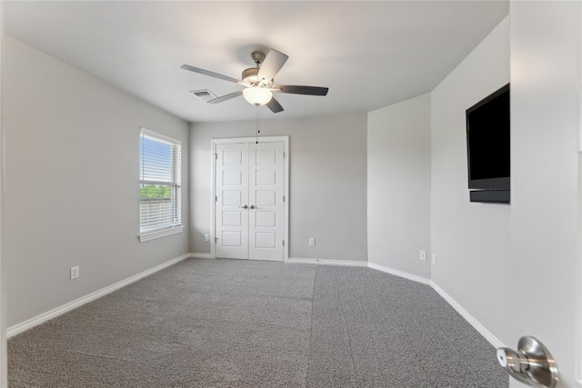 unfurnished bedroom featuring carpet, baseboards, a ceiling fan, and a closet