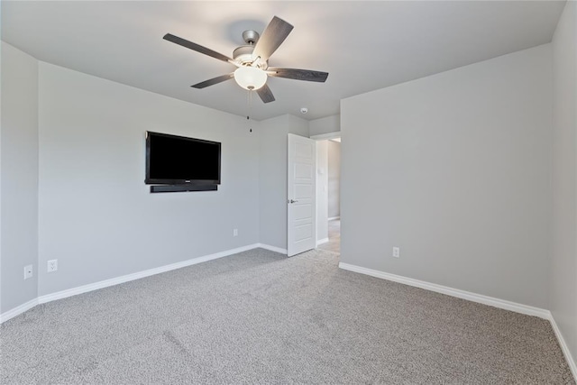 carpeted spare room with ceiling fan and baseboards