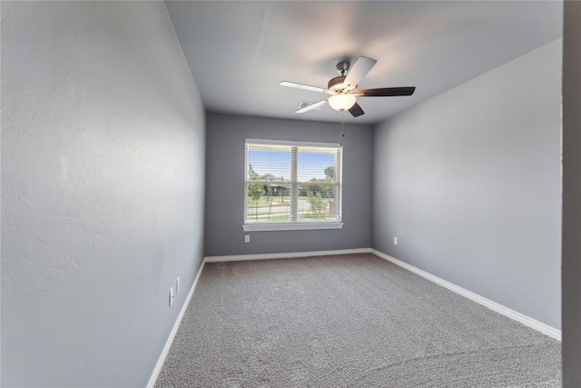 empty room with carpet flooring, a ceiling fan, and baseboards