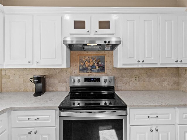2113 Castle Rock, Edmond, OK 73003 - kitchen featuring stainless steel electric stove, wall chimney exhaust hood, and tasteful backsplash