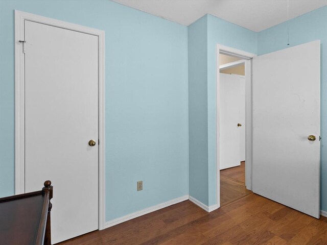 2113 Castle Rock, Edmond, OK 73003 - unfurnished bedroom with wood finished floors, baseboards, and attic access