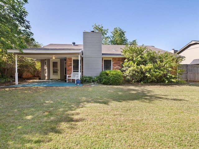 2113 Castle Rock, Edmond, OK 73003 - rear view of house with brick siding, a patio, a chimney, and a carport