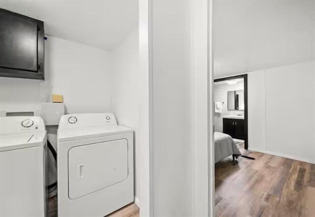 168 Bobber Rd, Broken Bow, OK 74728 - washroom with cabinet space, separate washer and dryer, and light wood-style floors
