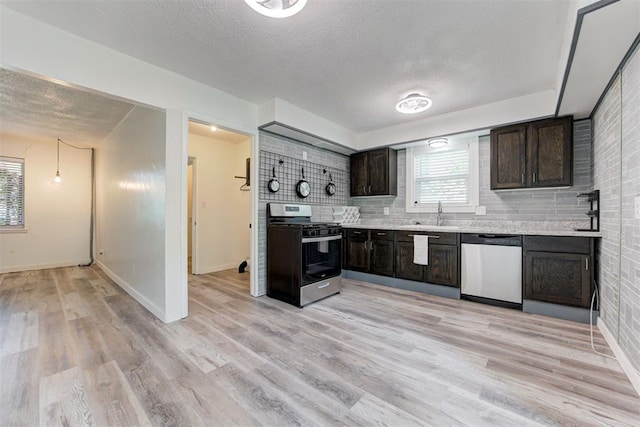 1316 W Logan Ave, Guthrie, OK 73044 - kitchen with stainless steel appliances, a textured ceiling, light countertops, dark brown cabinetry, and a sink