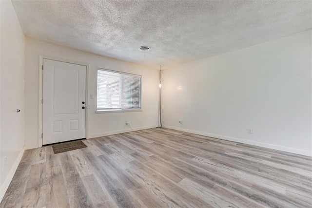 1316 W Logan Ave, Guthrie, OK 73044 - spare room featuring a textured ceiling, light wood-type flooring, and baseboards