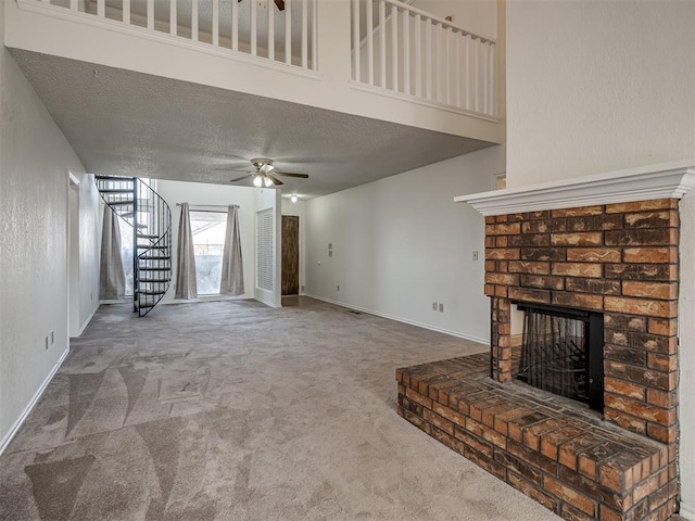 1108 SW 118th Pl, Oklahoma City, OK 73170 - unfurnished living room featuring a ceiling fan, a brick fireplace, stairway, carpet flooring, and a textured ceiling