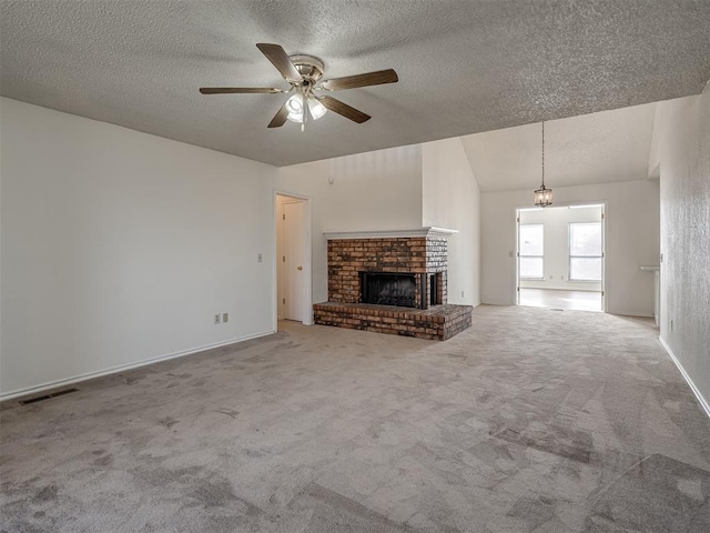 1108 SW 118th Pl, Oklahoma City, OK 73170 - unfurnished living room with carpet flooring, ceiling fan, a textured ceiling, a brick fireplace, and baseboards