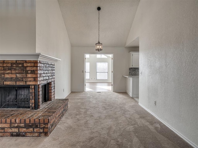 1108 SW 118th Pl, Oklahoma City, OK 73170 - unfurnished living room featuring light colored carpet, a textured wall, a brick fireplace, a textured ceiling, and high vaulted ceiling