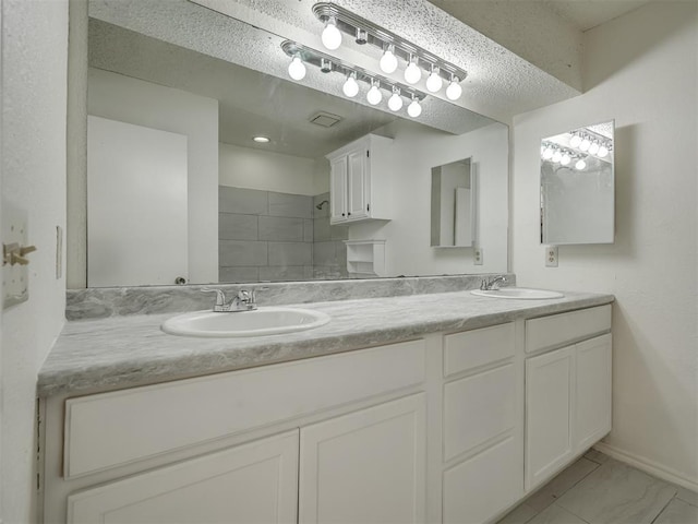 1108 SW 118th Pl, Oklahoma City, OK 73170 - full bathroom with double vanity, tiled shower, baseboards, and a textured ceiling