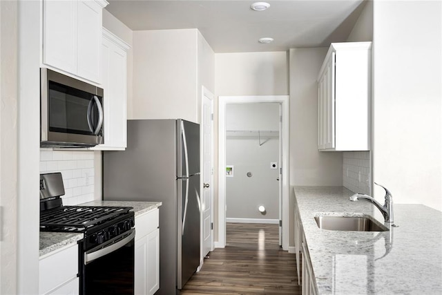 12700 Torretta Way, Yukon, OK 73099 - kitchen with stainless steel appliances, a sink, dark wood finished floors, decorative backsplash, and white cabinets
