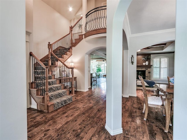 7612 NW 134th St, Oklahoma City, OK 73142 - entryway featuring arched walkways, plenty of natural light, a fireplace, wood finished floors, and crown molding