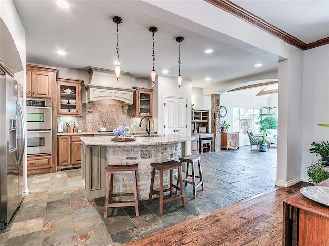 7612 NW 134th St, Oklahoma City, OK 73142 - kitchen featuring stainless steel appliances, stone tile flooring, recessed lighting, tasteful backsplash, and a breakfast bar area