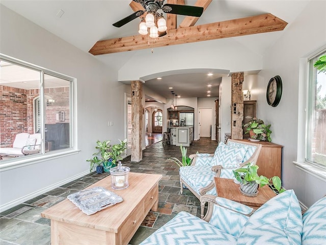7612 NW 134th St, Oklahoma City, OK 73142 - living room featuring arched walkways, stone tile flooring, decorative columns, ceiling fan, and baseboards