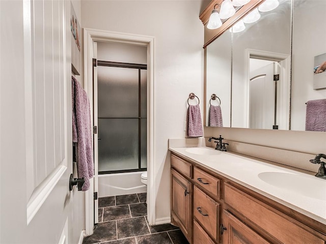 7612 NW 134th St, Oklahoma City, OK 73142 - full bath featuring double vanity, toilet, tile patterned flooring, and shower / bath combination with glass door