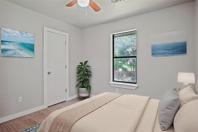 bedroom with wood finished floors, baseboards, and a ceiling fan