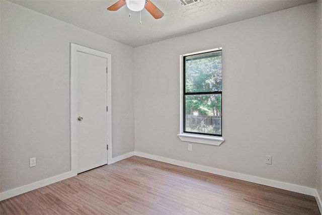 spare room with ceiling fan, wood finished floors, and baseboards