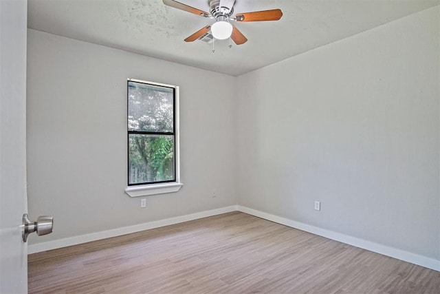 spare room with wood finished floors, baseboards, and a ceiling fan