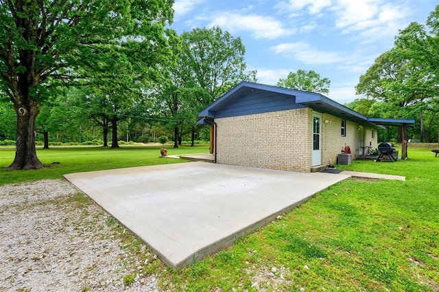 2590 Old 21 Rd, Idabel, OK 74745 - view of property exterior with brick siding, a patio area, and a lawn