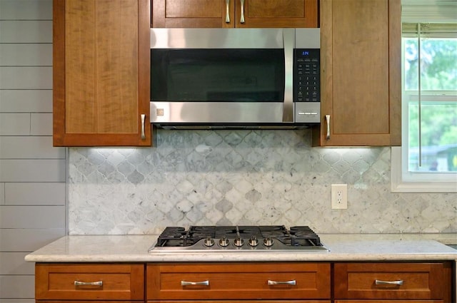 2590 Old 21 Rd, Idabel, OK 74745 - kitchen with stainless steel appliances, decorative backsplash, and brown cabinets