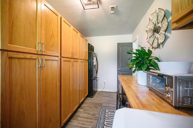 2590 Old 21 Rd, Idabel, OK 74745 - kitchen featuring butcher block counters, wood finished floors, baseboards, and freestanding refrigerator