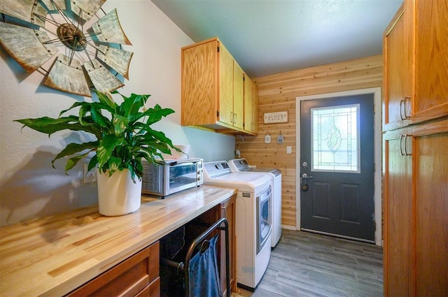 2590 Old 21 Rd, Idabel, OK 74745 - clothes washing area featuring cabinet space, separate washer and dryer, wood finished floors, and wooden walls